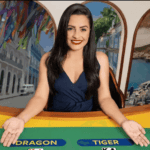 imagem de uma mulher sentada em uma mesa de Dragon Tiger, sinalizando com as mãos as cartas do jogo.