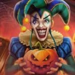 A spooky clown holds a Halloween-carved pumpkin, standing beside a magic book and an open chest with a treasure.