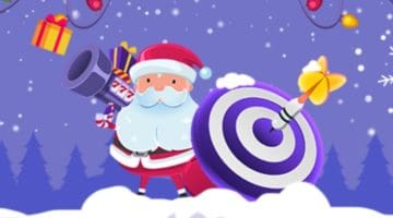 Santa holds a bazooka marked 777 and a shield with target circles drawn. A dart has hit the shield's center, and gift boxes fly in the air.