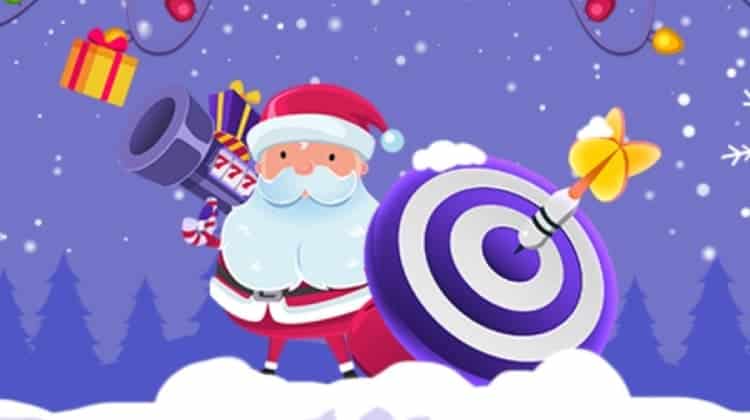 Santa holds a bazooka marked 777 and a shield with target circles drawn. A dart has hit the shield's center, and gift boxes fly in the air.