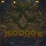 A decorated Christmas tree in a sphere and a sign reading "150 000 €" under holiday lamps at night.